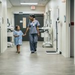 Nurse Holding Hands With Girl In Hospital